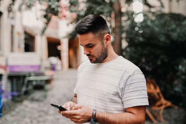 Man filling out a post-stay survey while outside