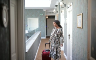 Hotel guest walking to their room, which is a great time for them to receive a hotel welcome email