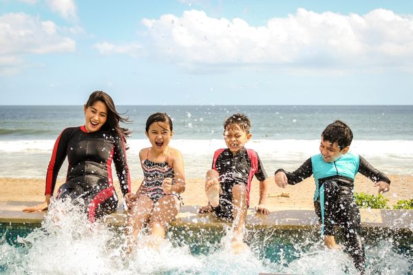 Family enjoying their vacation while splashing in the pool