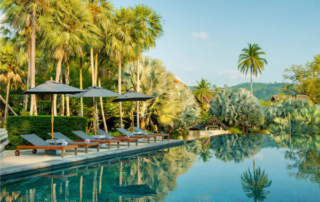 The Slate, a Phuket Pearl Resort, property with poo chairs, palm trees and an infinity pool
