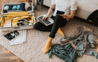 person packing while looking at their laptop