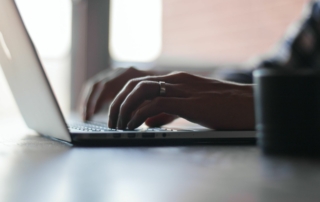 Close-up shot of someone typing on a computer