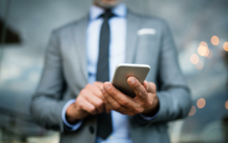 A business person looks down at their phone.
