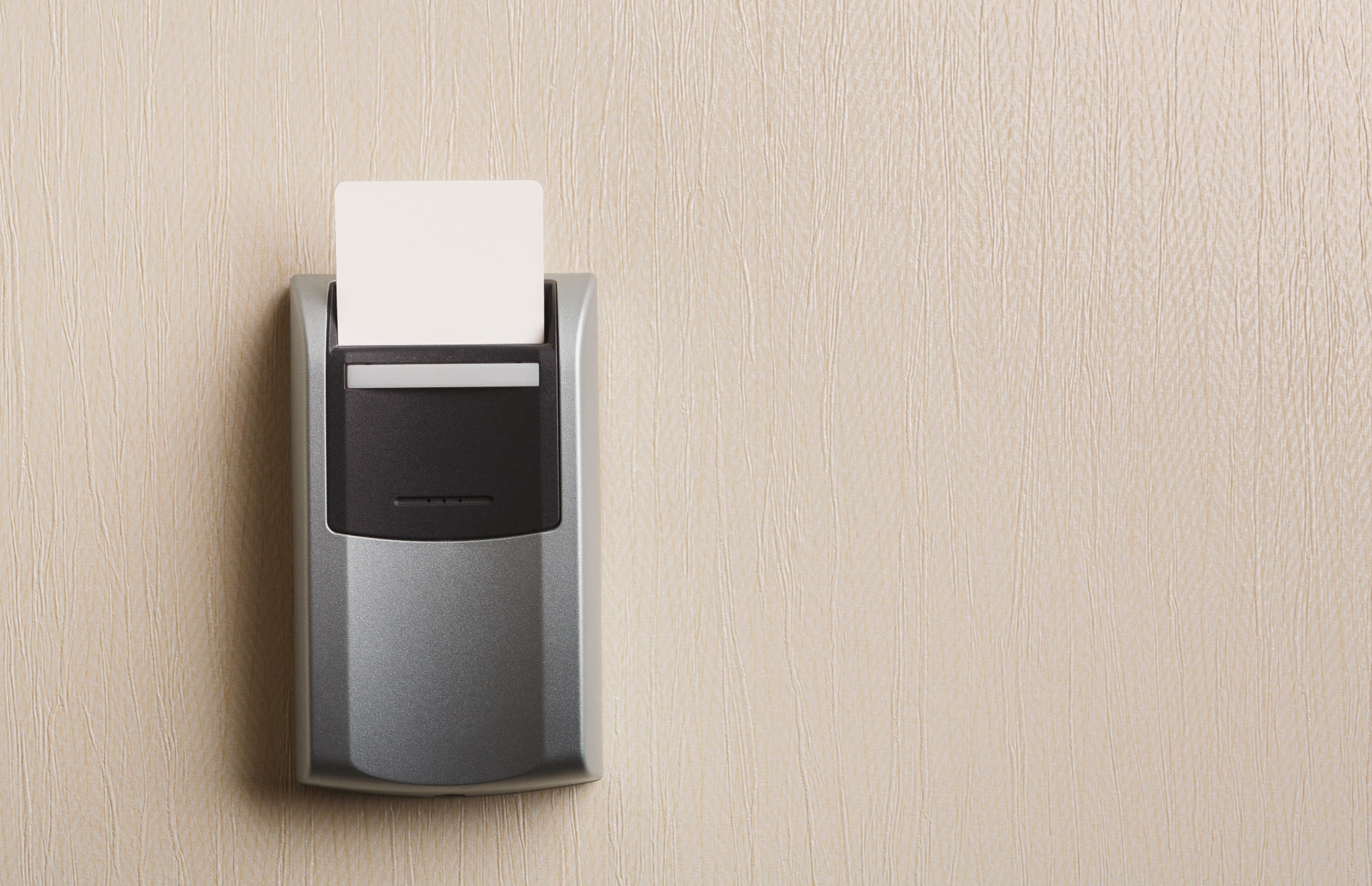 A key card is inserted into an electronic hotel room lock.