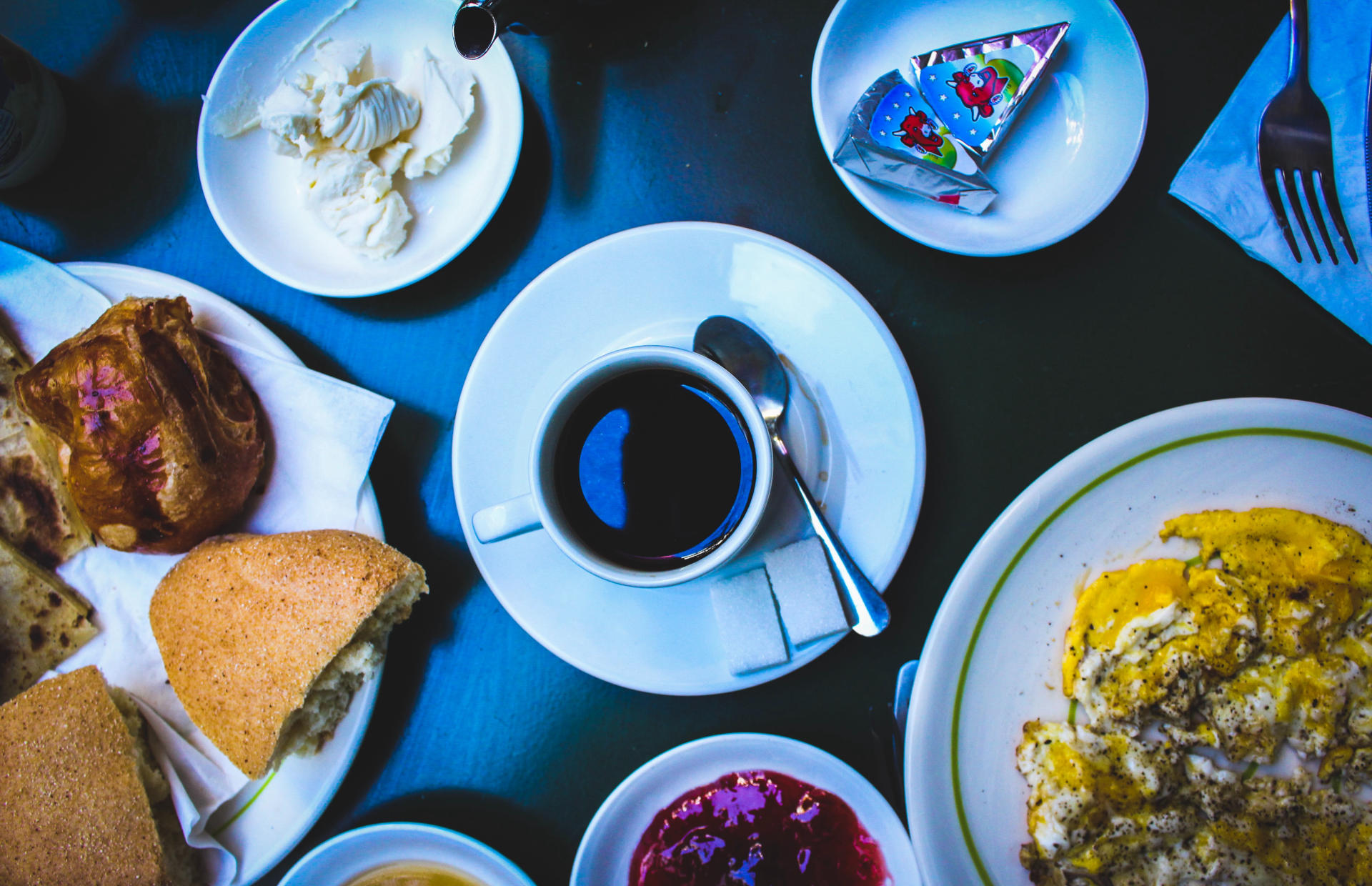 Trays of food and coffee sit on a table.