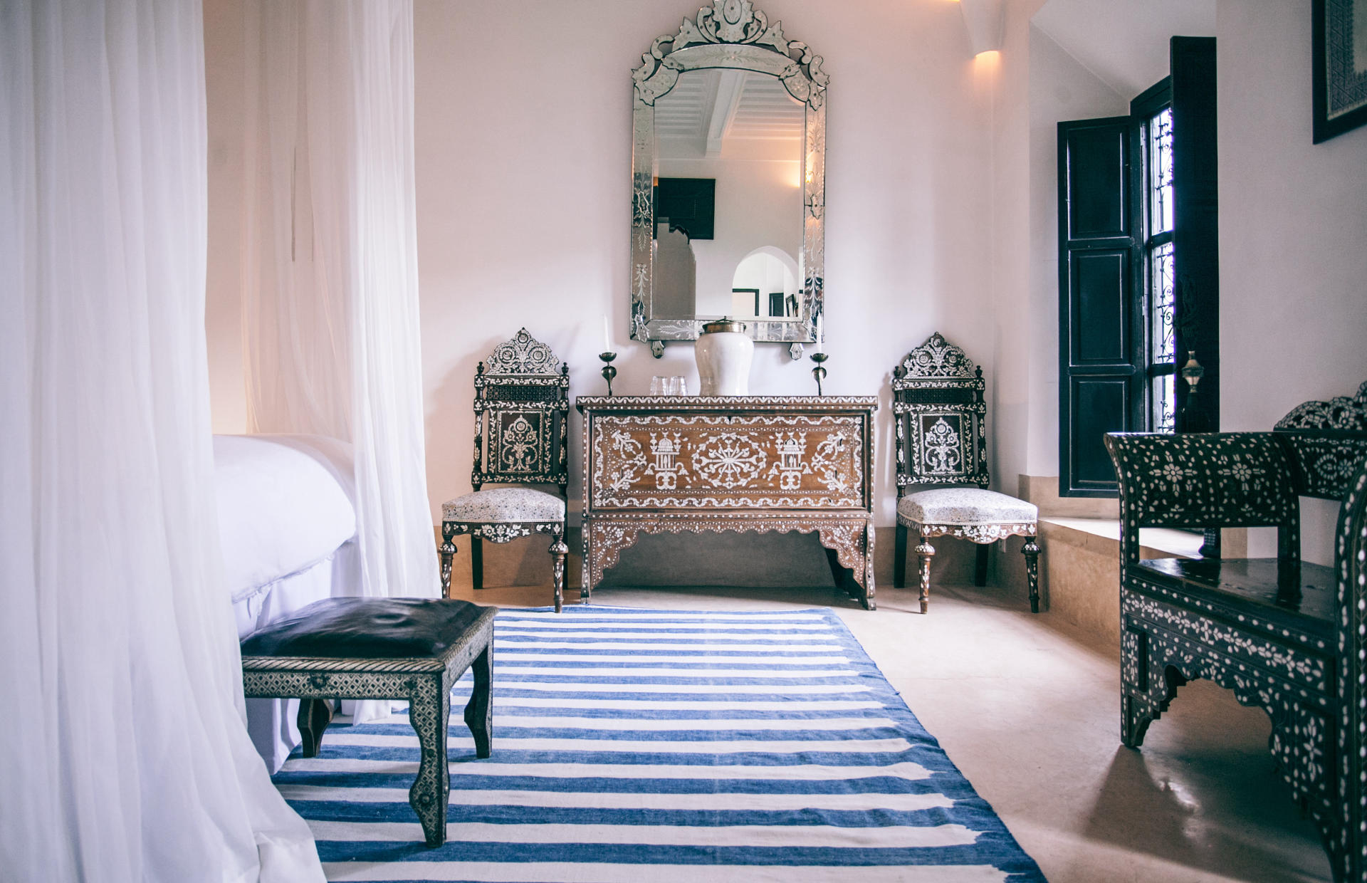 A hotel room is decorated with ornate tables and chairs.