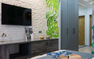 A hotel room has a television on the wall.