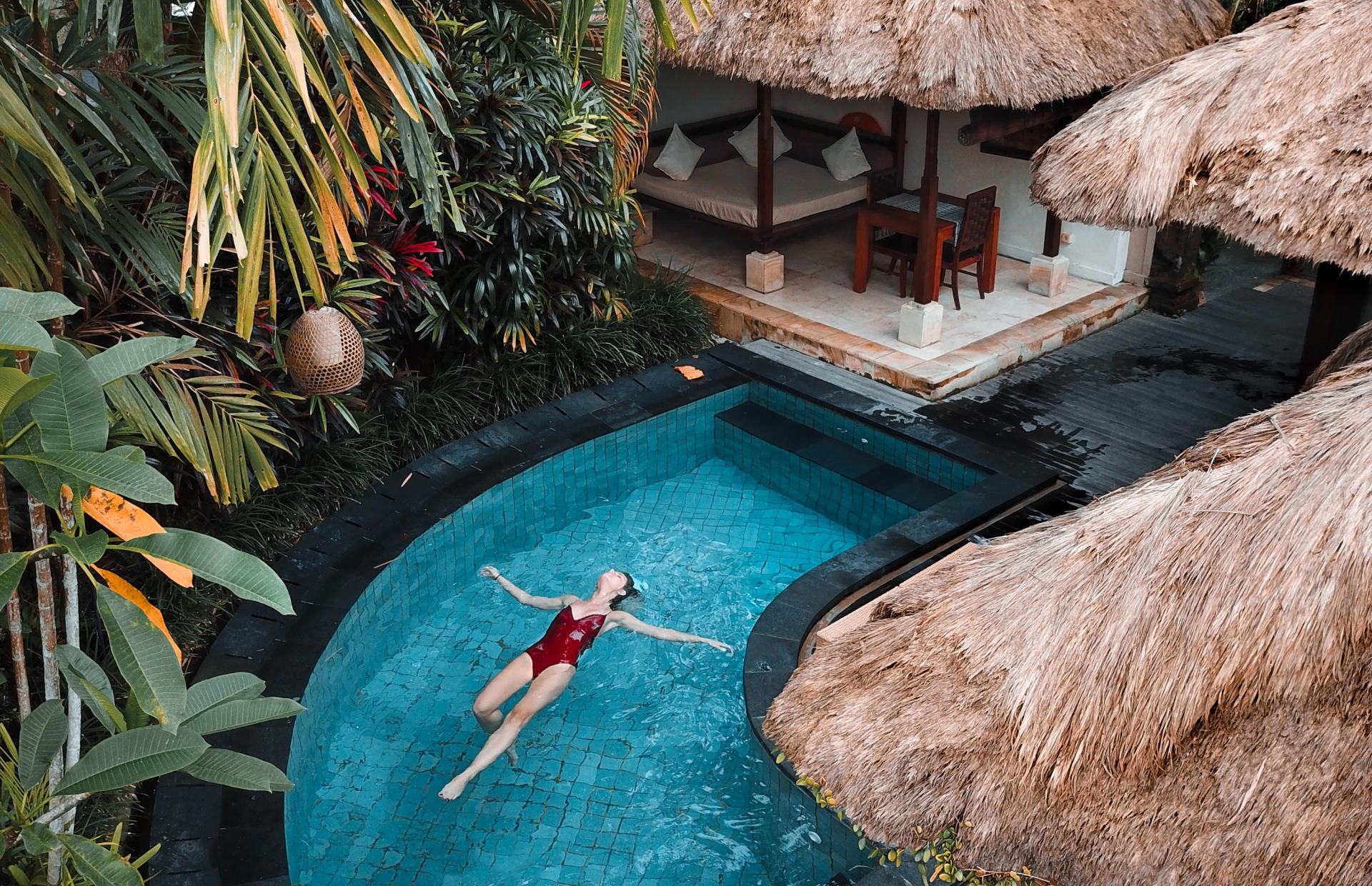 A guest in a red bathing suit floats in a resort pool.