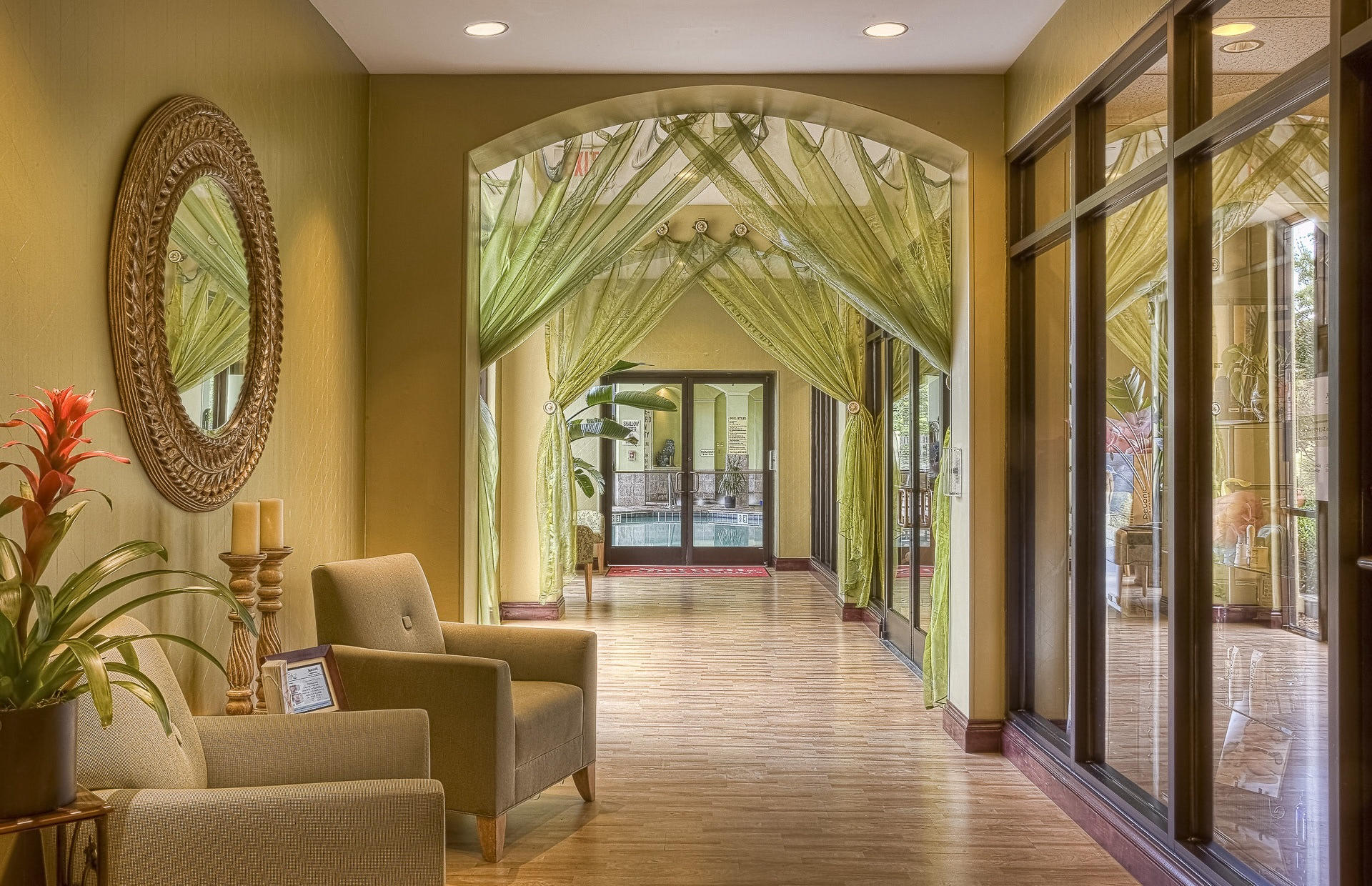 A hotel lobby is decorated with green curtains.