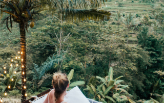 A hotel guest looks out into the forest below.