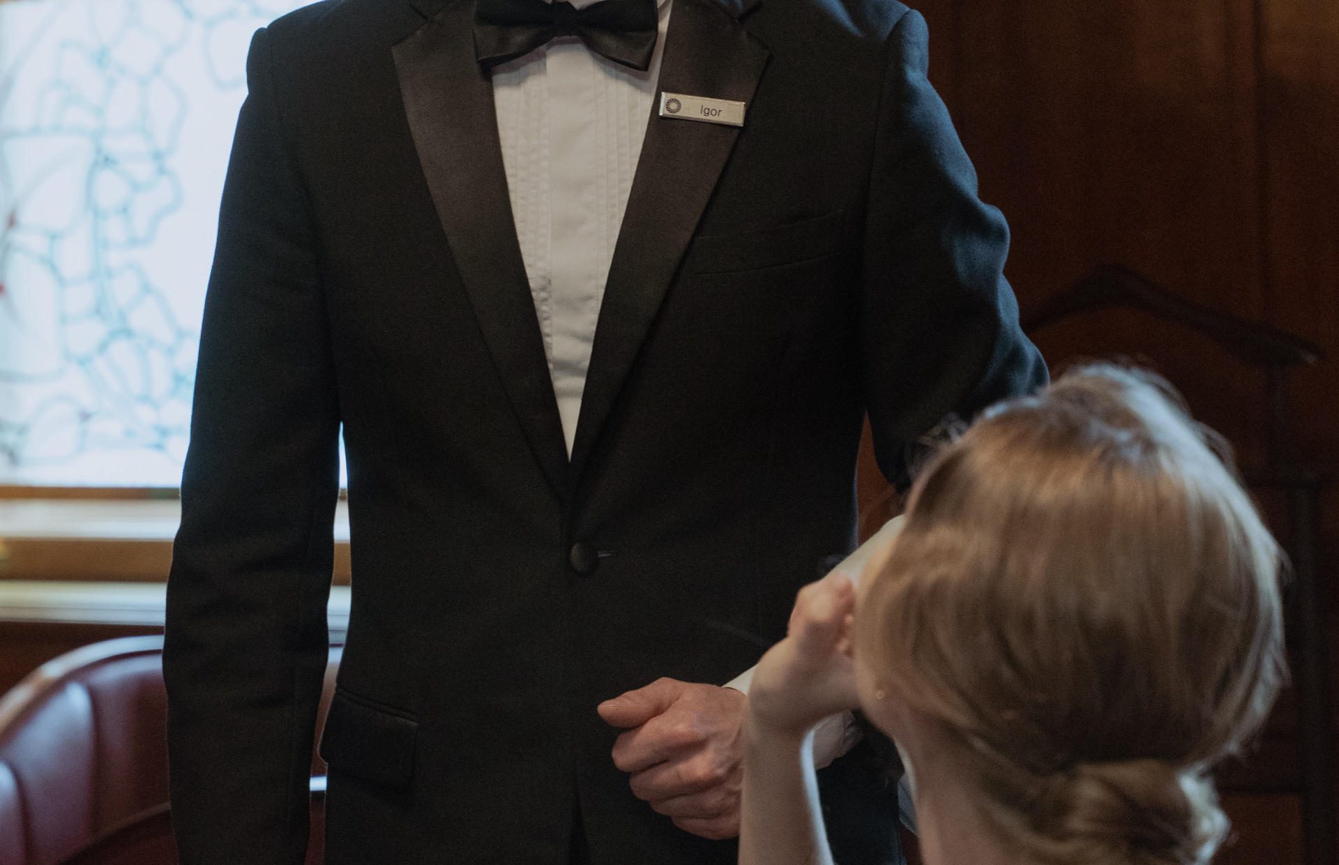 A hotel staff member waits on a guest.