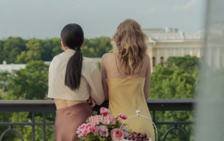 Two guests stand at a hotel balcony.