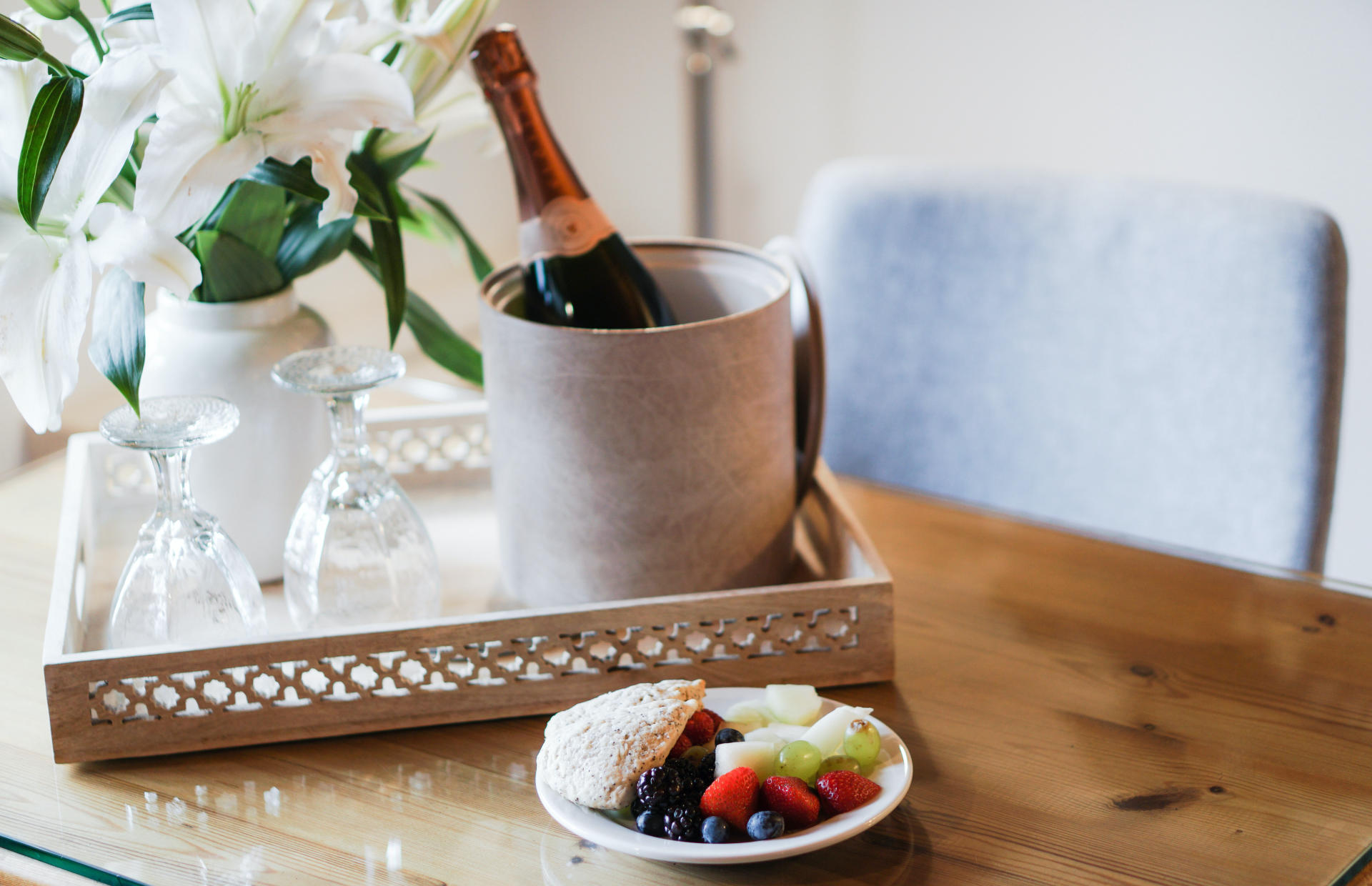 A bottle of wine and a late of foot sit on a table.