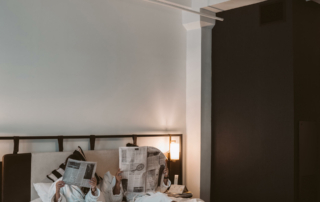 Two guests read the newspaper in bed.