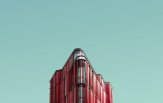A pink hotel is positioned against a blue sky.