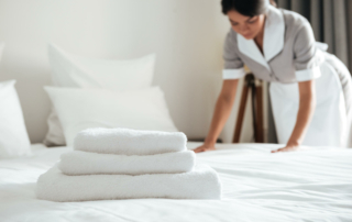A woman is making up a hotel bed.