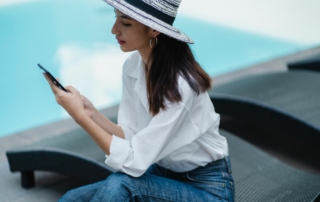 Hotel guest reading a text message from Ivy, Revinate's text messaging solution, outside by the pool