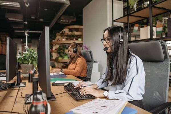 2 hotel call center agents working with guests over the phone