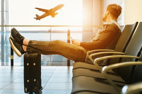 Traveler reading a hotel newsletter while waiting at an airport gate