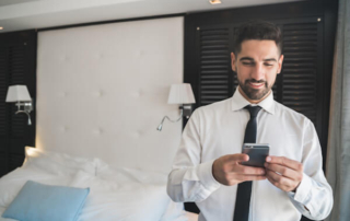 Businessman uses cell phone in hotel room