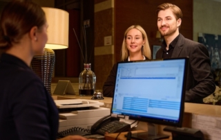 Hotel data management with receptionist looking at guest data - Revinate