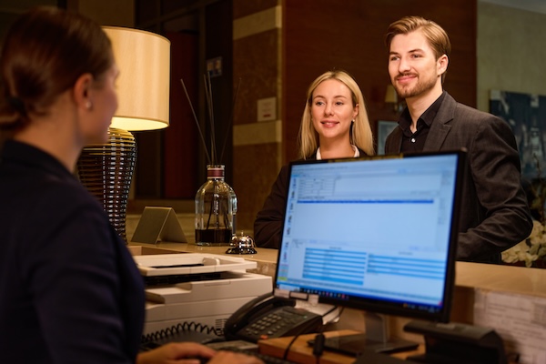 Hotel data management with receptionist looking at guest data - Revinate