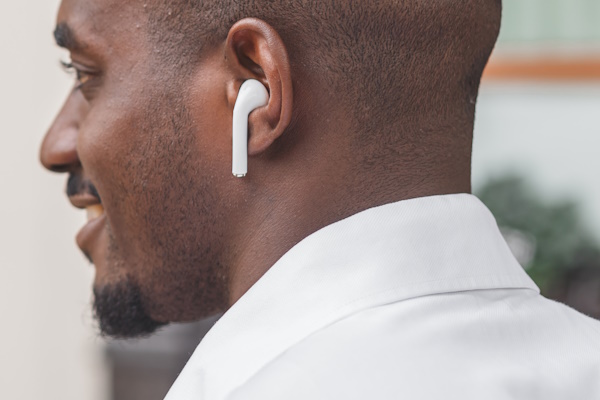 Close-up image of a guy in a profile listening to music via earbuds Close-up image of a guy in a profile listening to music via earbuds