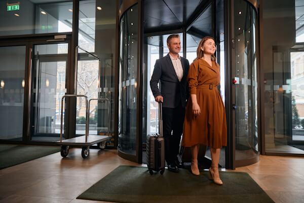 Adult Caucasian couple entering hotel.