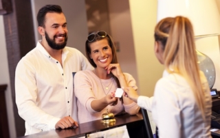Couple at reception desk in hotel.