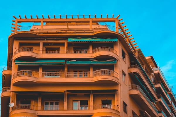 Orange hotel exterior against a blue sky.