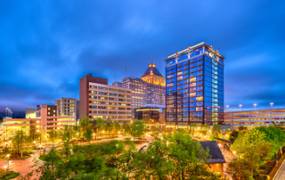 Hotel exterior at night against a cityscape