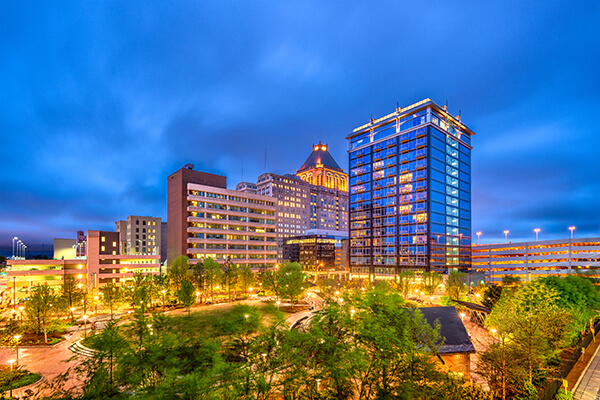 Hotel exterior at night against a cityscape