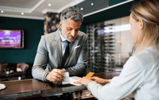 Older man checks in at hotel reception desk